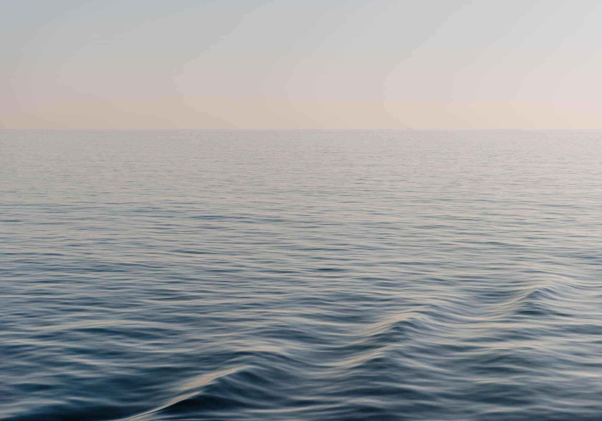 Calm ocean waves under clear sky.
